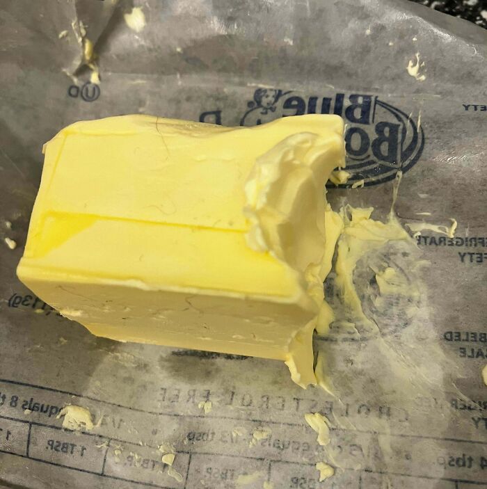 Partially eaten butter with crumbs and smudges on wrapper showing signs of roommate annoyance jerks.