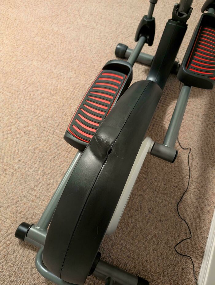 Exercise machine with damaged plastic casing, showing an infuriating example of men being men in home gym setup.