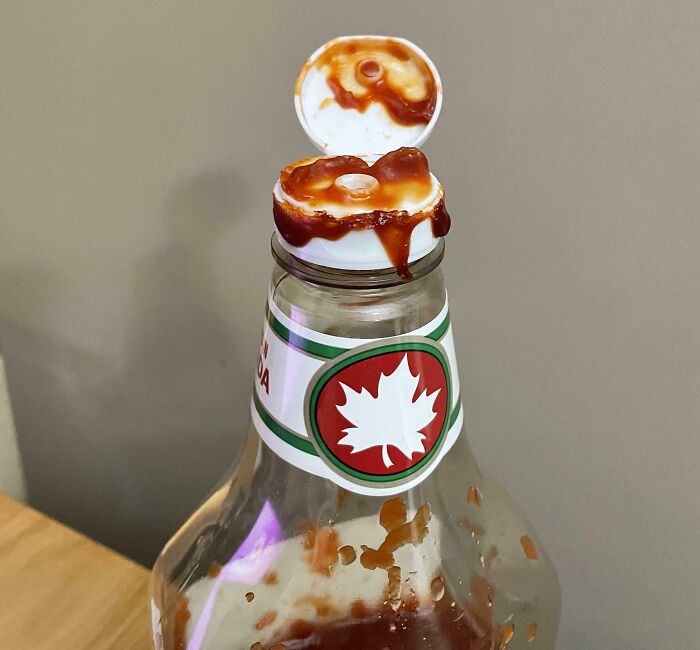 Ketchup bottle with cap covered in sauce, illustrating infuriating examples of men being men in everyday life.