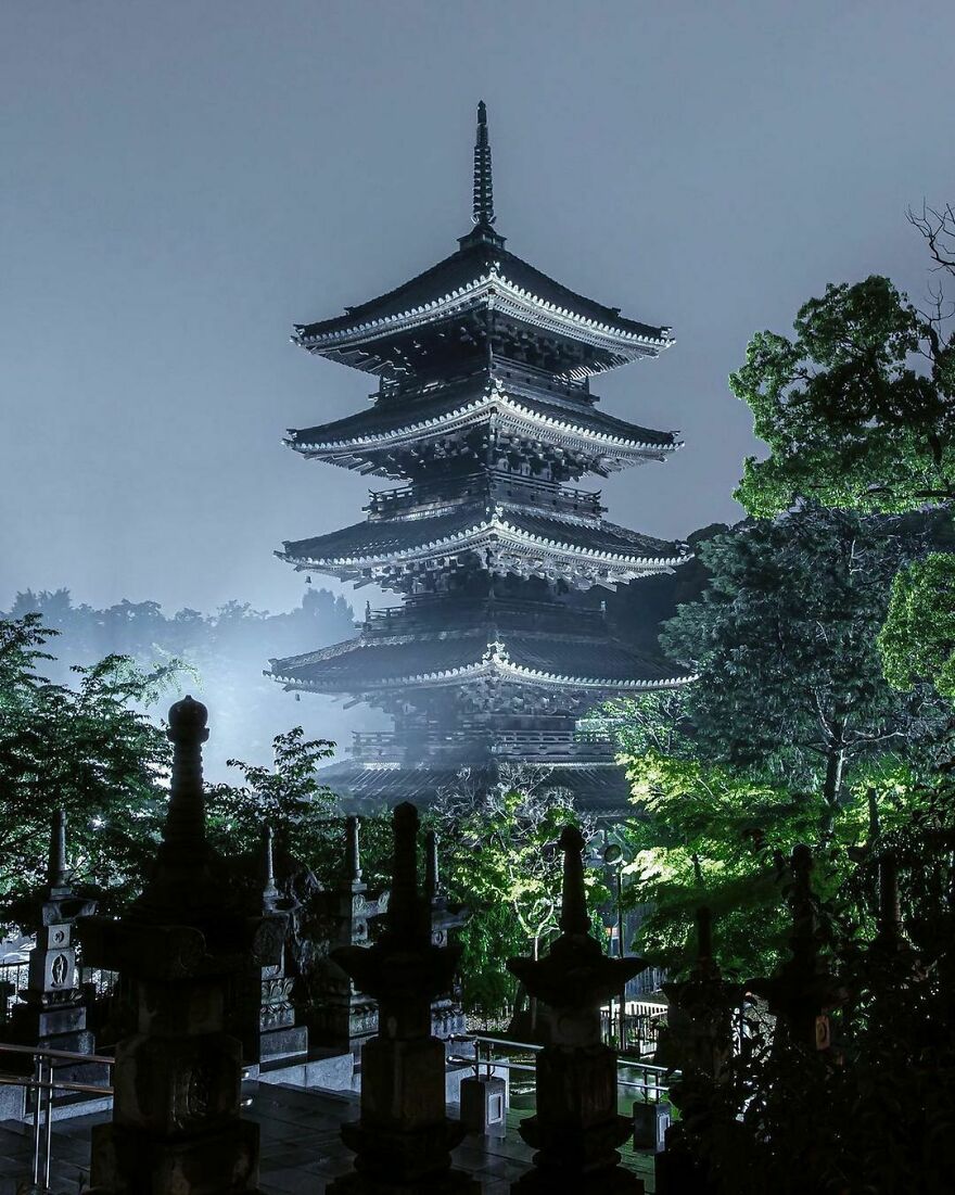 Traditional Japanese pagoda illuminated at night surrounded by trees showcasing unique Japanese architecture style.