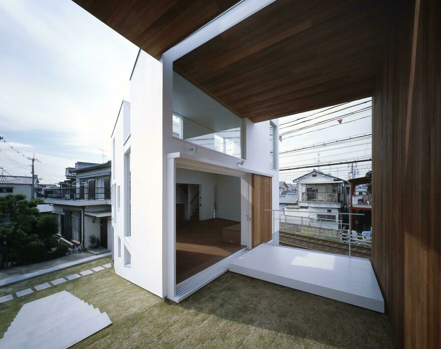 Modern Japanese architecture example featuring a white minimalist house with wooden ceiling and open living space.