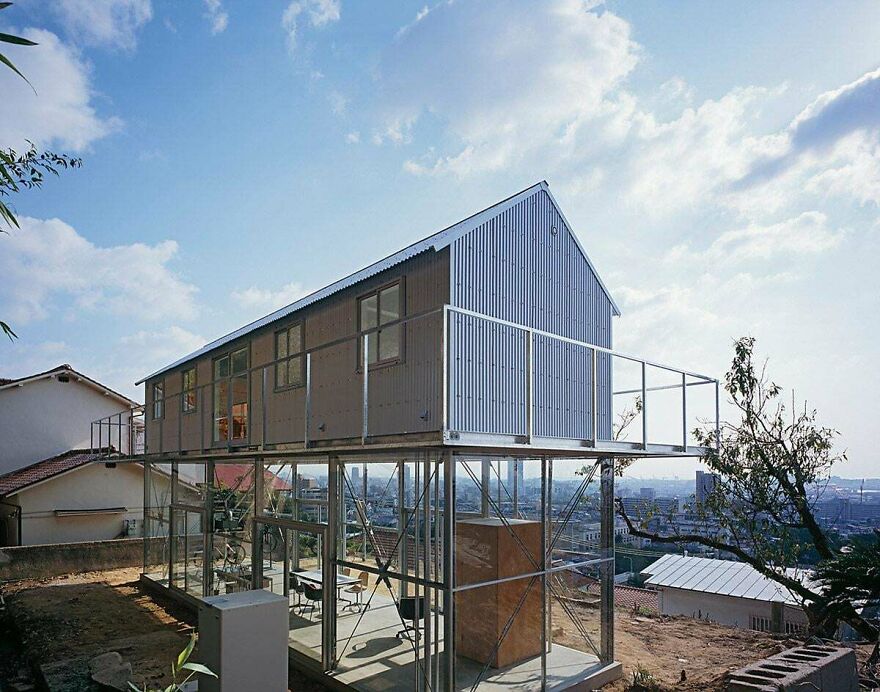 Modern elevated house with glass and metal structure showcasing unique Japanese architecture design.