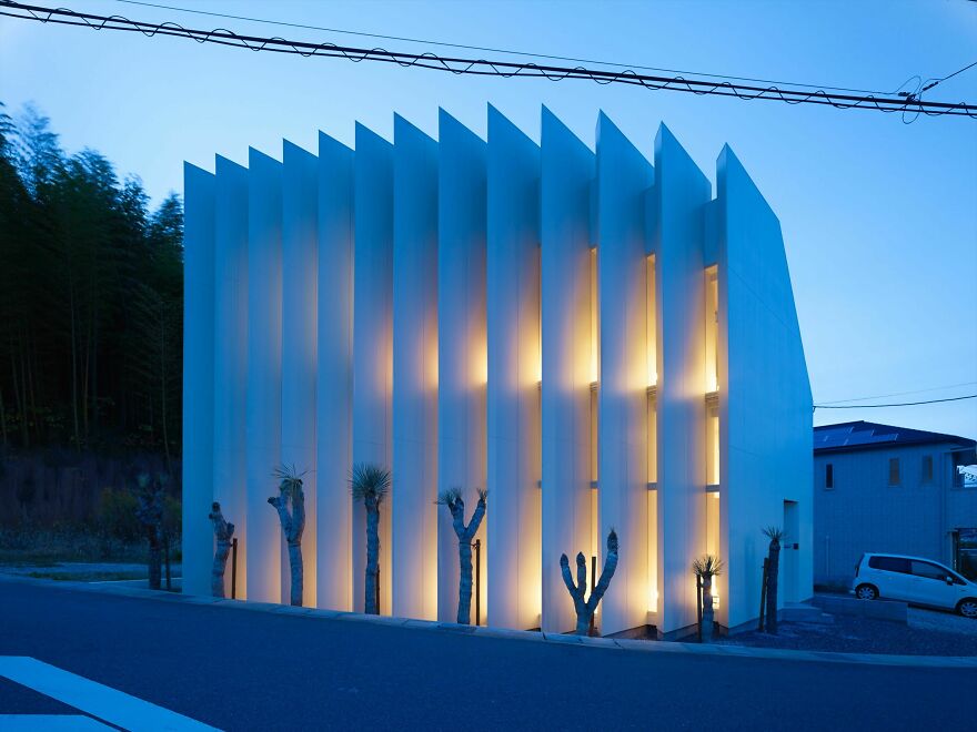 Modern building with vertical architectural fins illuminated at dusk showcasing unique Japanese architecture design.