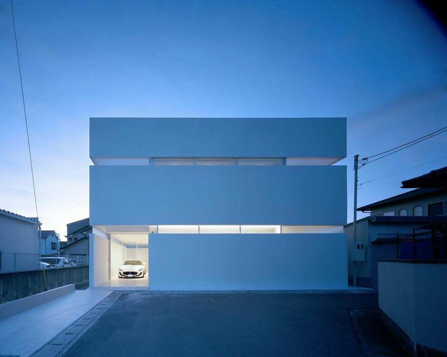 Minimalist modern Japanese architecture with clean lines and geometric shapes in a residential setting at dusk.