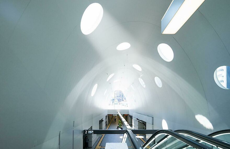 Modern interior of a railway station showcasing unique circular skylights and elements of Japanese architecture design.