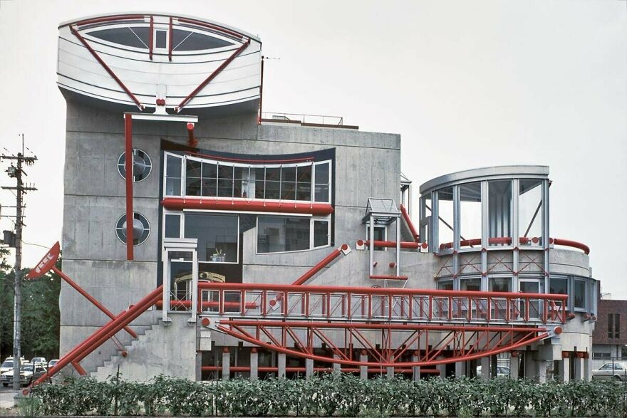 Modern Japanese architecture featuring concrete and red steel beams in an innovative and interesting structural design.