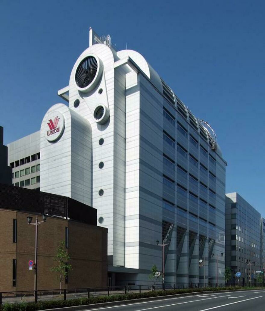 Modern white commercial building with circular vents and windows, showcasing unique Japanese architecture design elements.