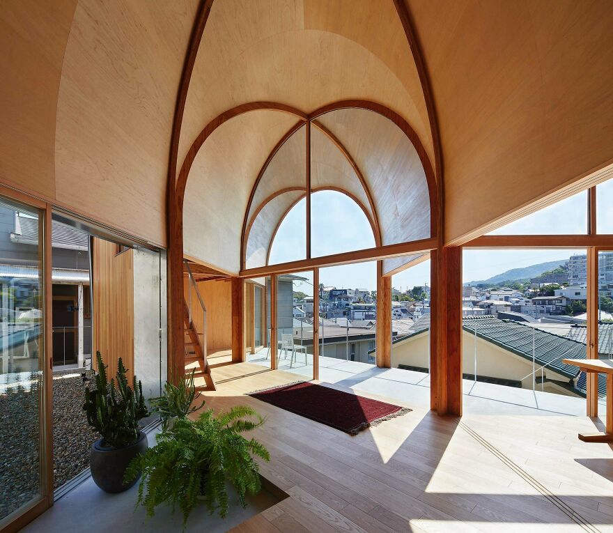 Modern Japanese architecture interior with wooden arches, large windows, and natural light overlooking a cityscape view.