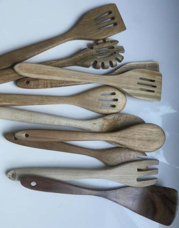 Various wooden kitchen utensils arranged on a white surface, illustrating infuriating examples of men being men.