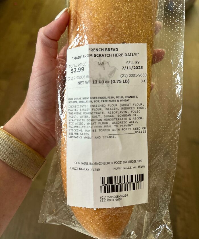 Hand holding packaged French bread showing label and ingredients, an example of men being men humor in everyday life.