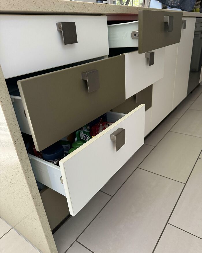 Kitchen drawers left partially open showing a common example of men being men and causing mild household frustration.