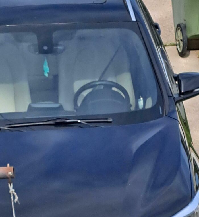 Front view of a black car with a large dent on the hood, highlighting poor driving and dumb drivers.