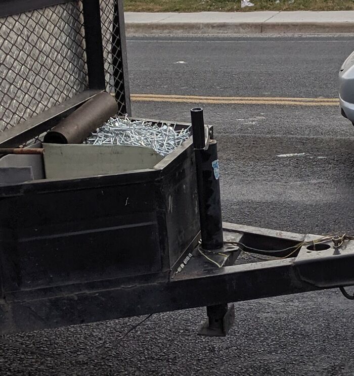 Trailer full of loose screws posing a hazard on the road, captured as part of dumb drivers being shamed and unbelievable driving fails.