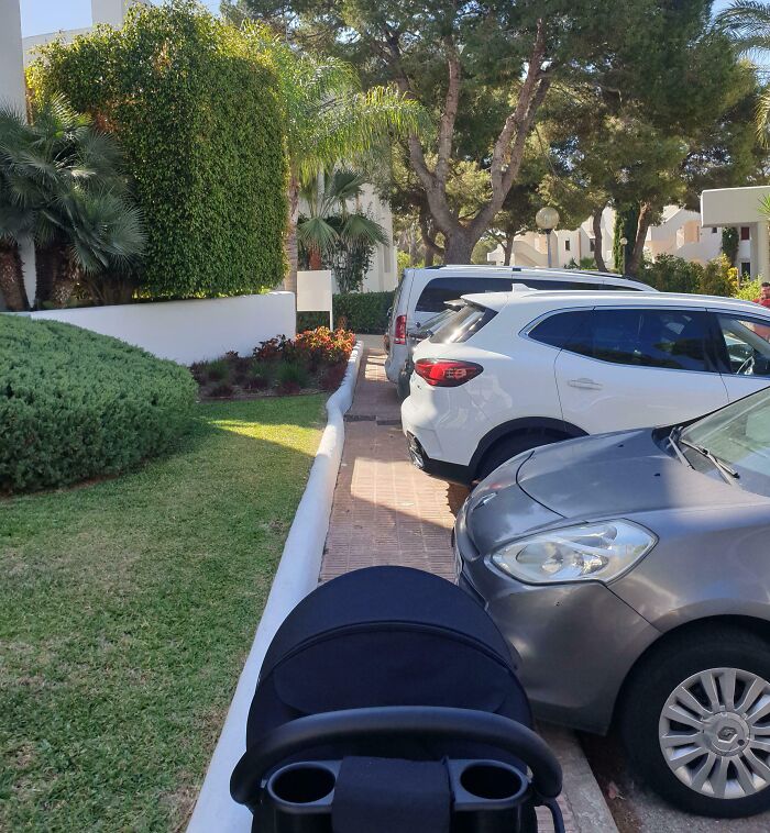 Narrow walkway blocked by improperly parked cars, illustrating dumb drivers causing pedestrian inconvenience.