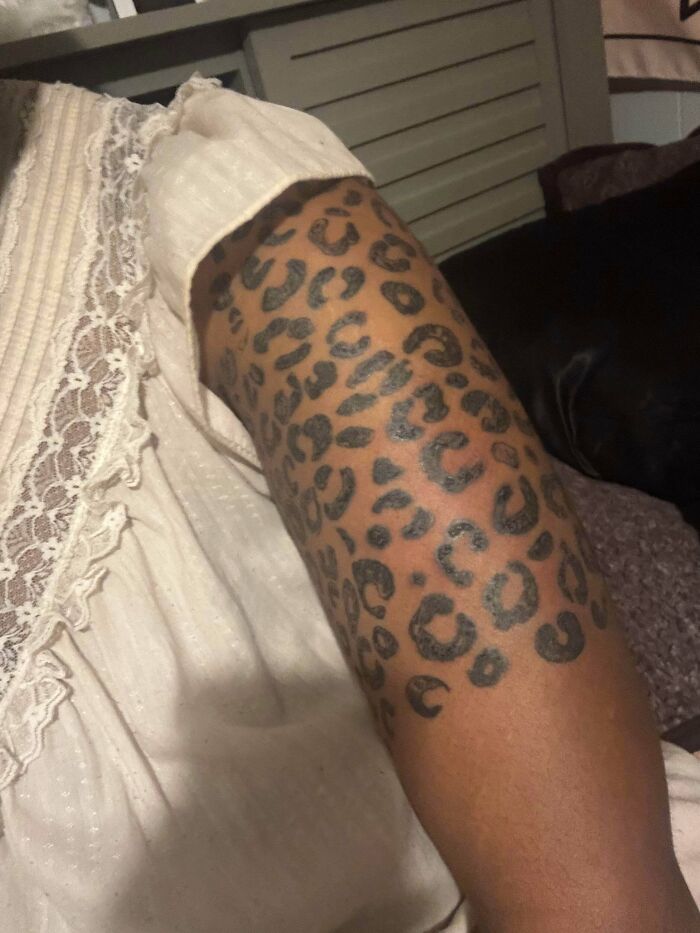 Leg tattoo of irregular leopard print spots on a person's leg showcasing a bad tattoo design and poor tattoo choice.
