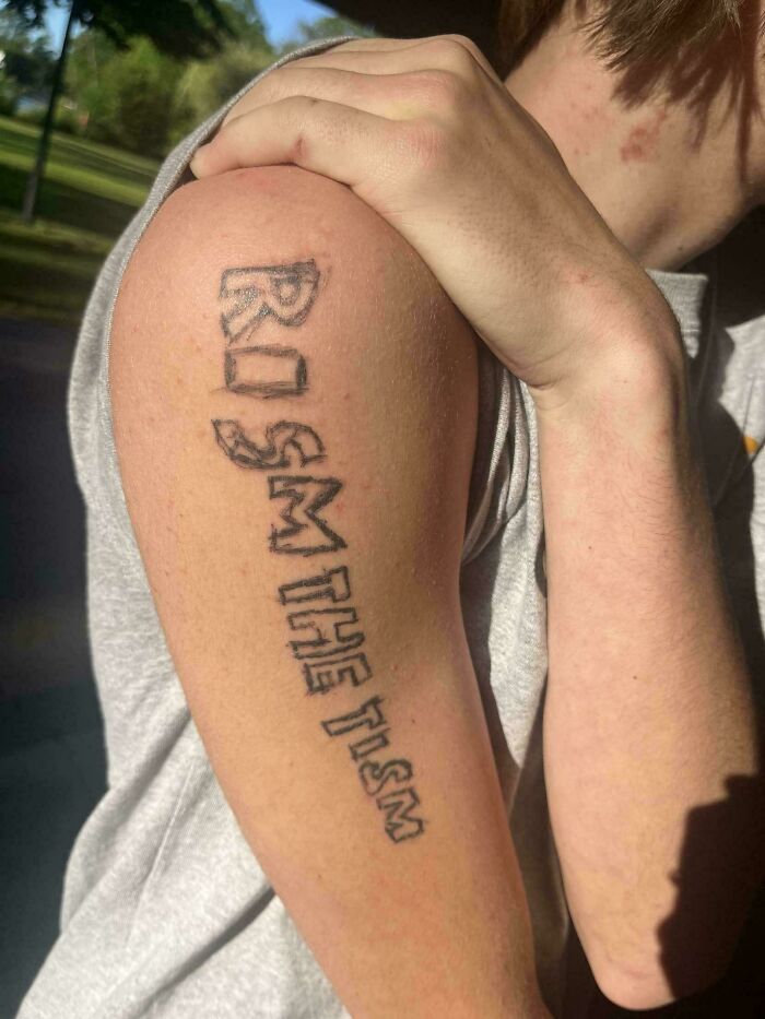 Tattoo on upper arm with badly misspelled words showing a clear example of bad tattoos and poor planning.