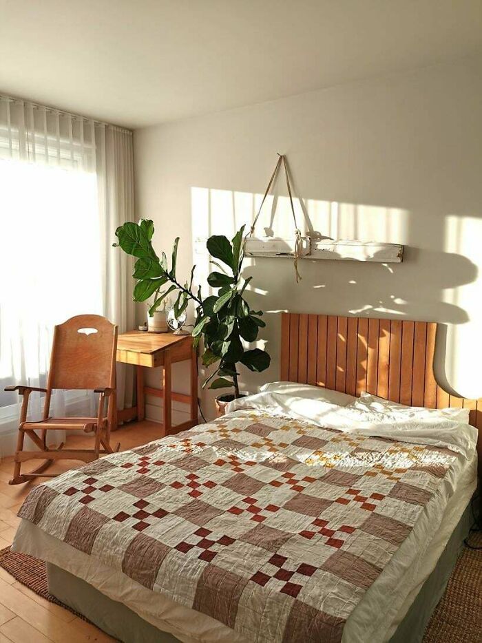 Cozy bedroom with wooden furniture and sunlight, illustrating subtle effects of consumerism in daily life.