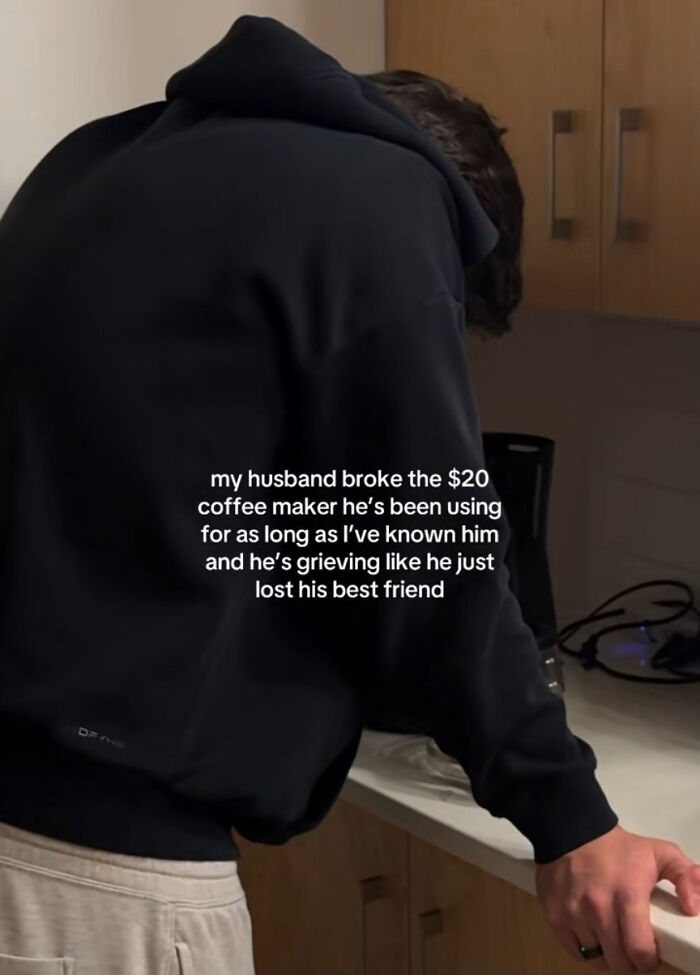 Man grieving over broken $20 coffee maker in kitchen, reflecting on how bad consumerism has become.
