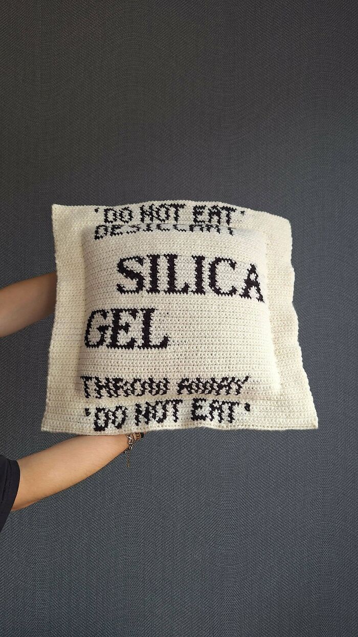 A person holds a large, awesome crocheted silica gel packet pillow, a testament to hours of creative crafting.