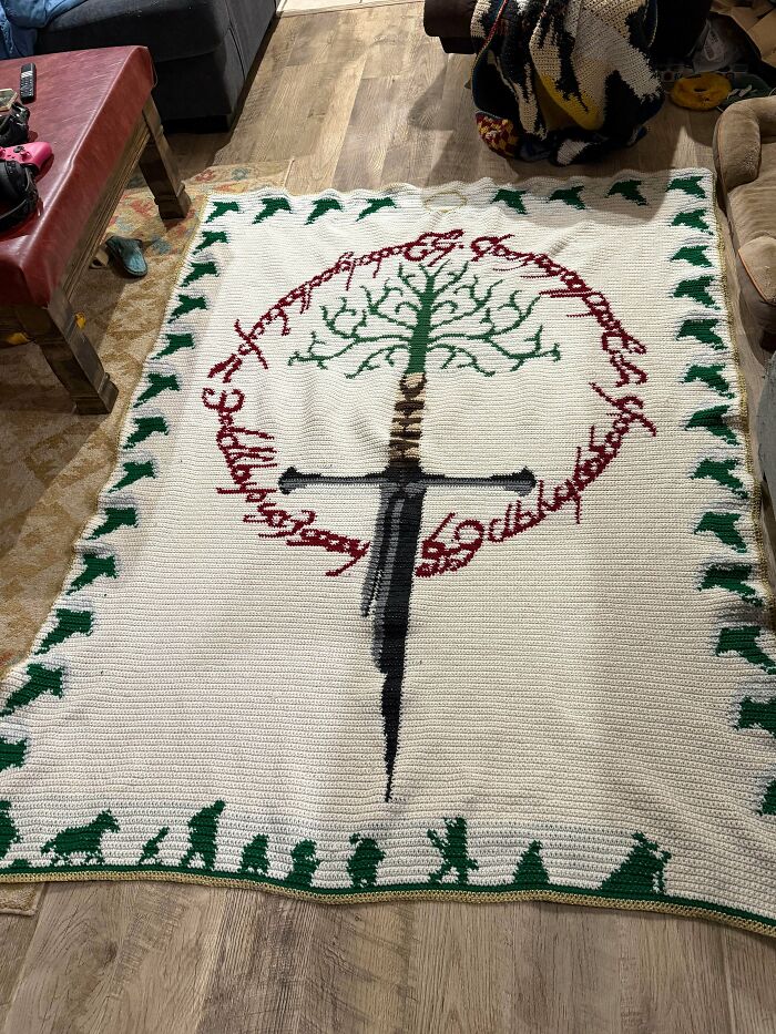 Awesome crocheted blanket featuring the Tree of Gondor and Narsil from Lord of the Rings, with Hobbits walking below.