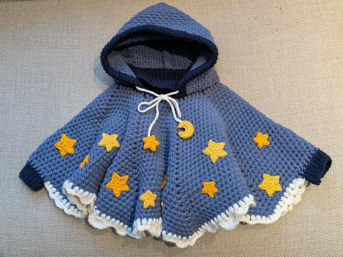 Awesome crocheted blue hooded cape with yellow stars and a crescent moon, a delightful craft project.