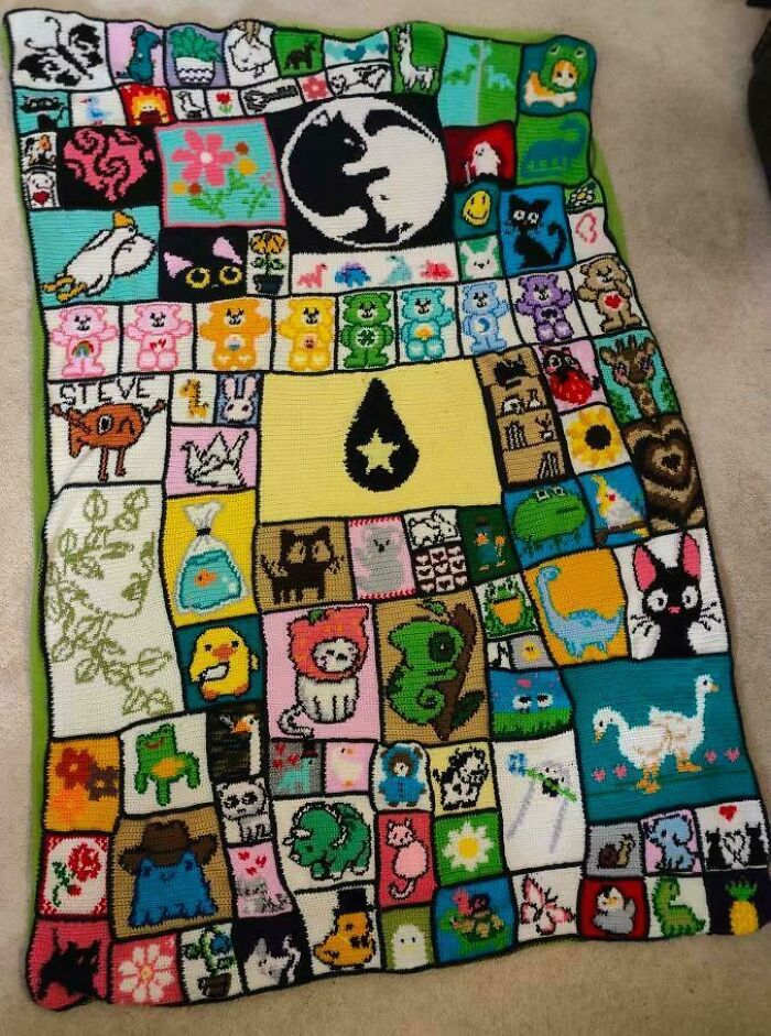 An awesome crocheted blanket, featuring many colorful squares with diverse characters like Care Bears, cats, and dinos.