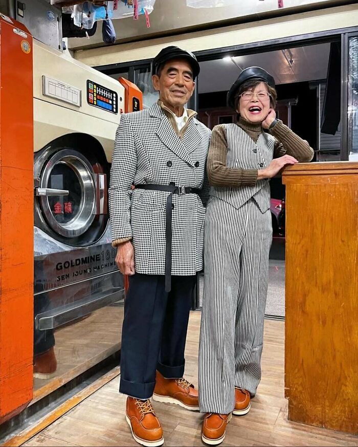 Amazing photo of an elderly couple in stylish outfits inside a laundromat, showcasing their vibrant style.