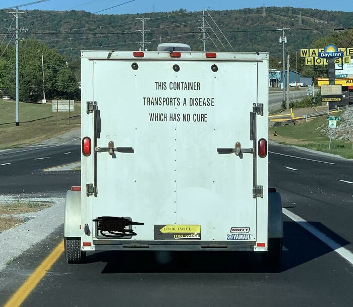 Creepy image: A white trailer on a road with the text THIS CONTAINER TRANSPORTS A DISEASE WHICH HAS NO CURE. Hair of kids.