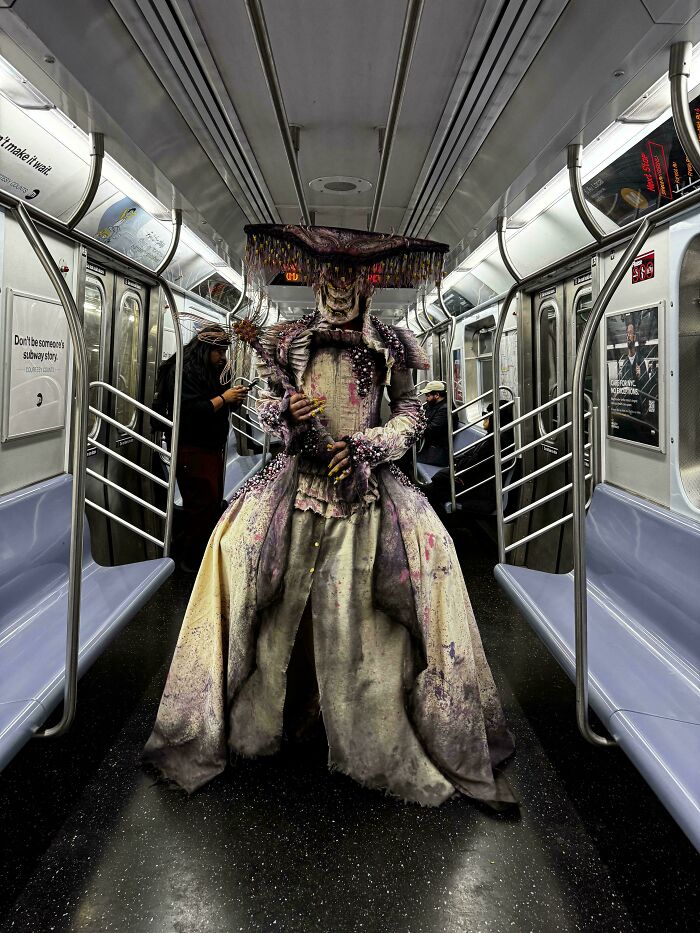 Creepy image of a person in an elaborate, terrifying costume on a subway, illustrating images that might make "Hair Of Kids" stand up.