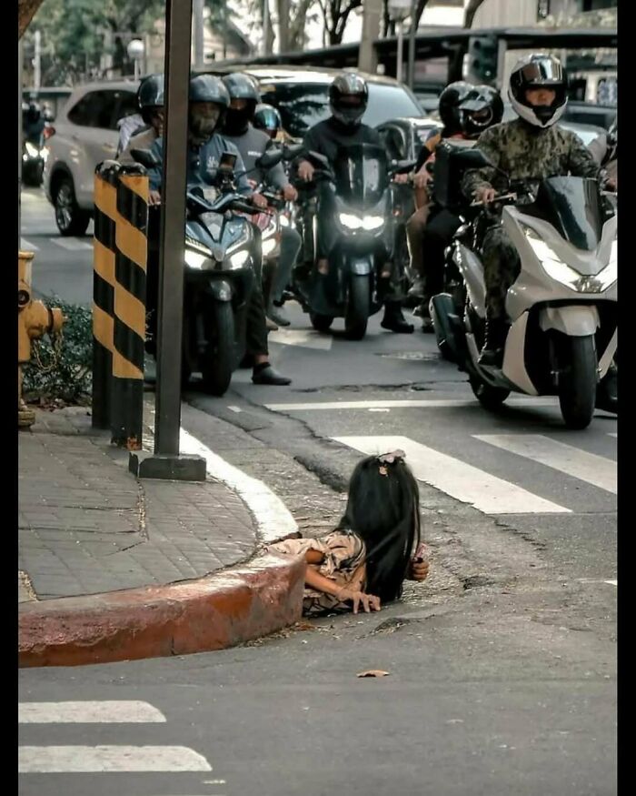 Creepy image of a long-haired doll or "Hair Of Kids I Babysit" on a sidewalk as traffic waits.