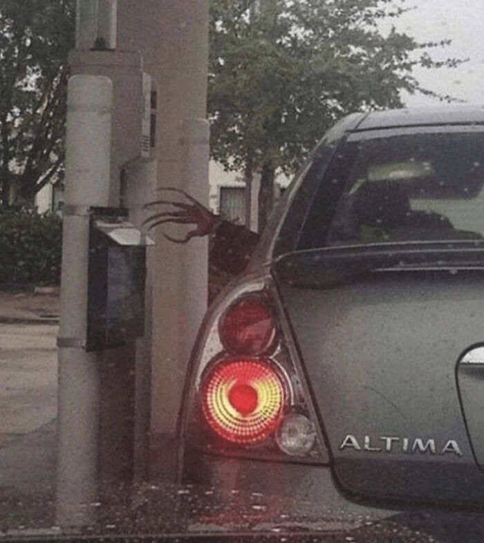Creepy image of a ghoulish hand reaching from behind a pole next to a car, hinting at scary encounters for kids I babysit.
