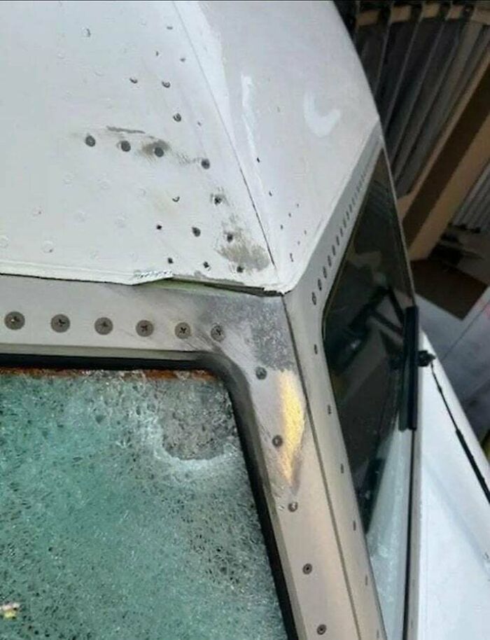 Airplane cockpit with shattered windshield and dented roof, showing significant damage from an accident. This fail looked expensive.