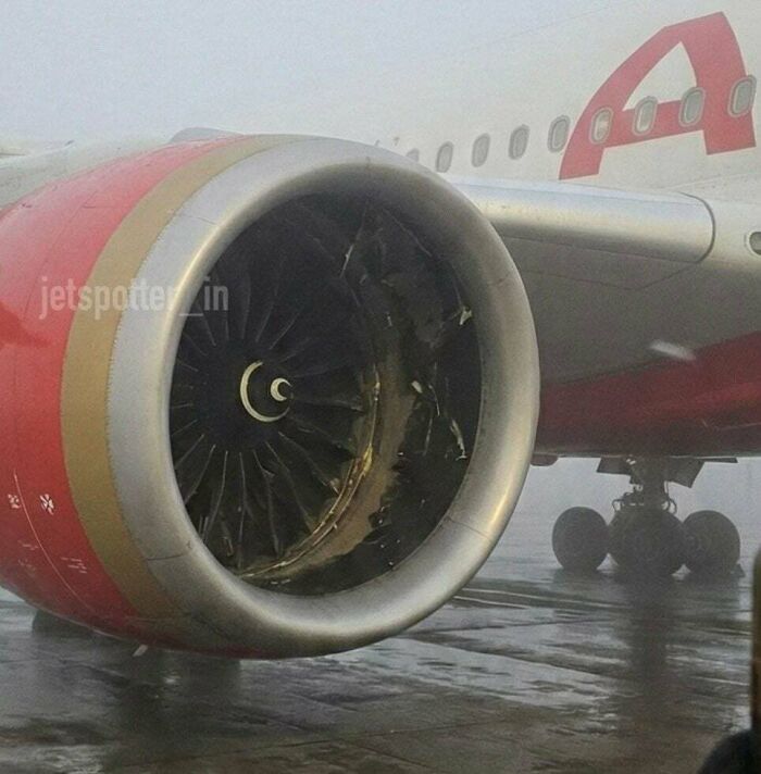 A damaged airplane engine, an accident that looks expensive, with bent blades visible inside the cowling.
