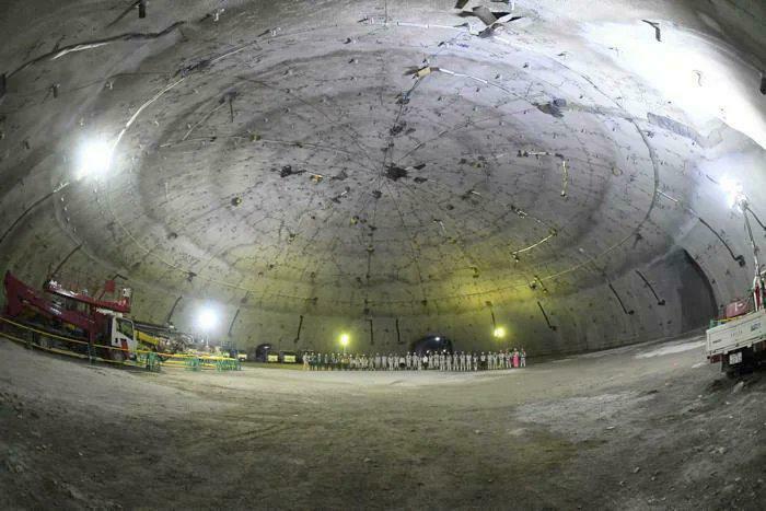 An extremely large and eerie underground dome structure with tiny workers, a truly large thing.
