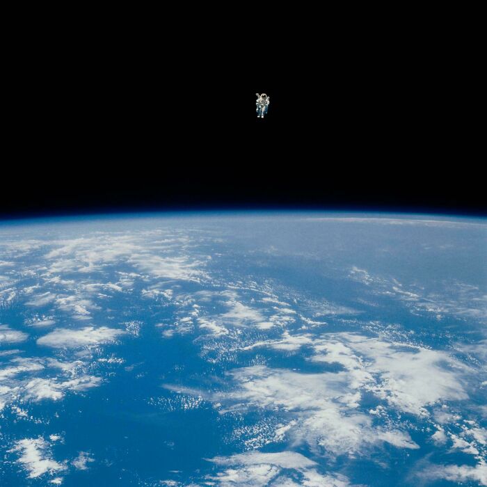 An astronaut floats above an extremely large and eerie Earth, a scary and large thing in space.