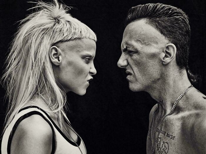 A man and a woman face each other, both with severe and unfortunate haircuts.