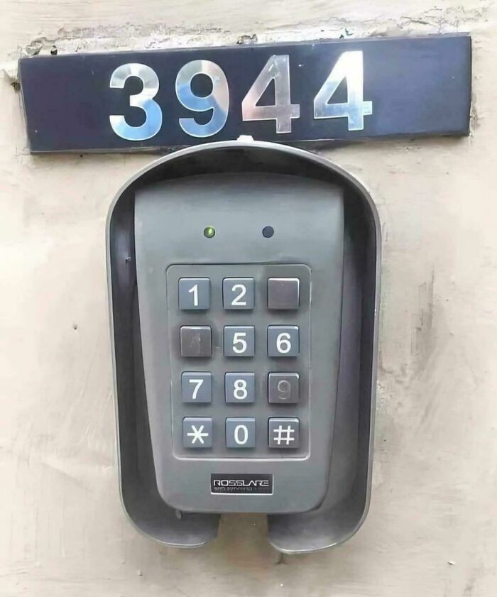 Keypad with some buttons missing and an address number 3944 above it, showcasing a common sense fail in outdoor installation.