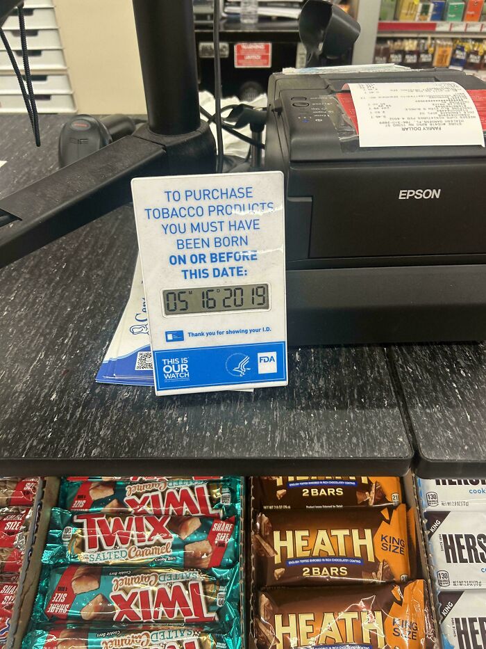 ID check sign at a store counter with an impossible birthdate shows a common sense fail in retail compliance.