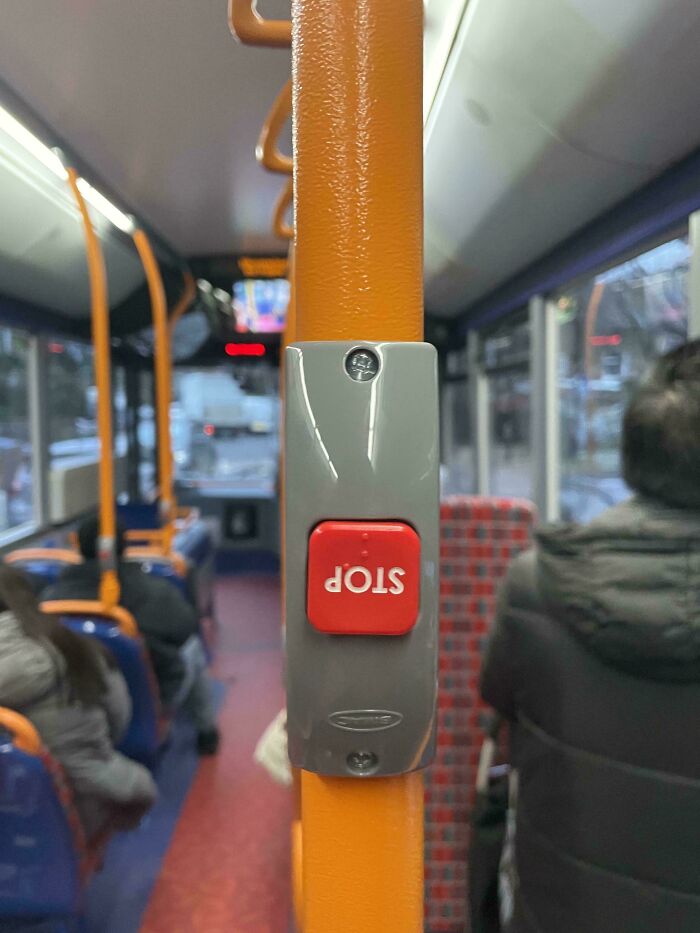 Stop button installed upside down on a bus pole, showcasing a funny you had one job fail and common sense mistake.