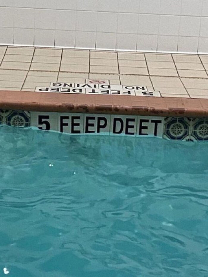 Pool depth sign painted incorrectly showing "5 feep deet" instead of 5 feet deep in a common sense fail.