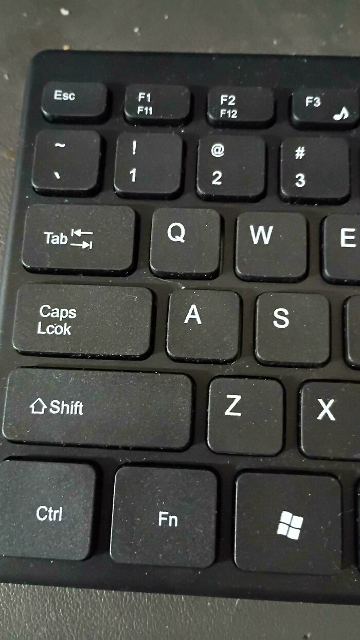 Close-up of a keyboard fail showing a Caps Lock key misspelled as Caps Lcok in a common sense you had one job fail.