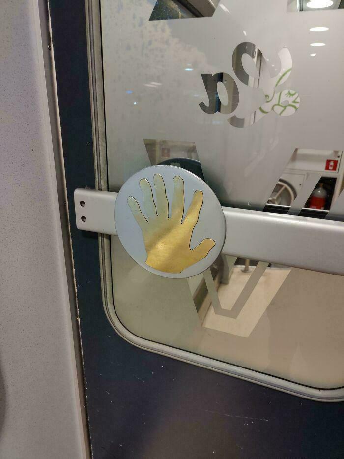 Door handle with a gold hand sticker placed incorrectly, illustrating a ridiculous you had one job fail in common sense.