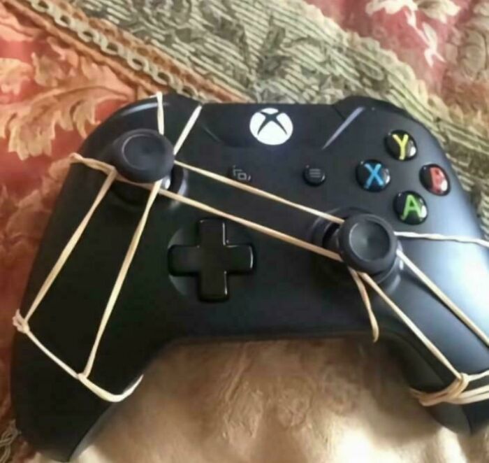 Xbox controller with rubber bands wrapped around the joysticks showing redneck engineering improvisation to fix broken parts.
