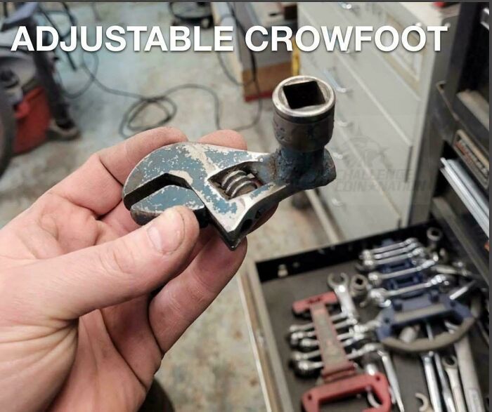 Hand holding a small adjustable crowfoot tool, an example of redneck engineering in a workshop setting.