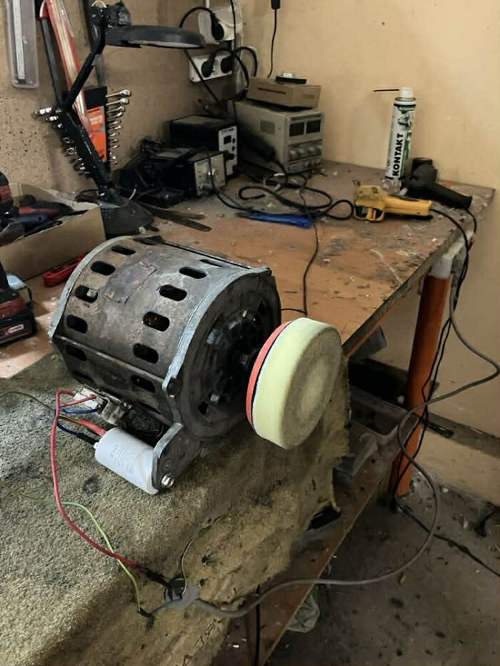 Homemade redneck engineering device with motor and polishing pad on a cluttered workbench in a workshop.