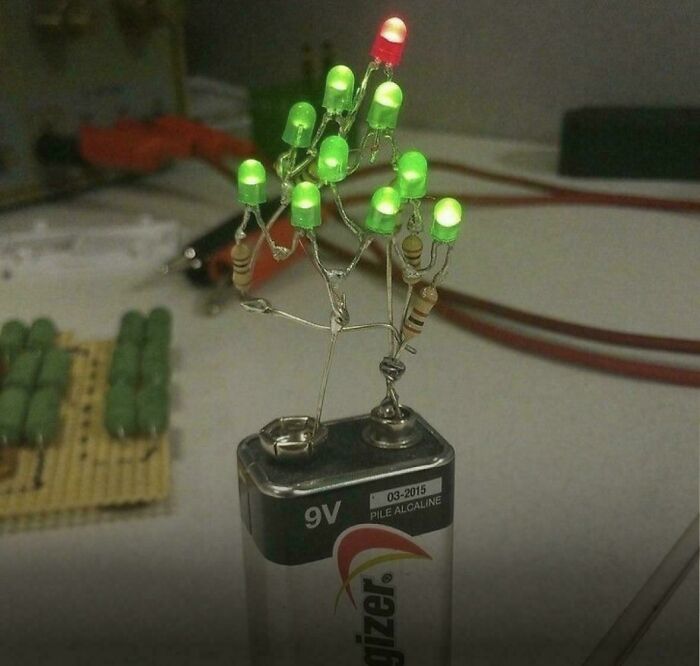 Battery-powered circuit with LEDs and resistors wired in a makeshift design showcasing redneck engineering creativity.