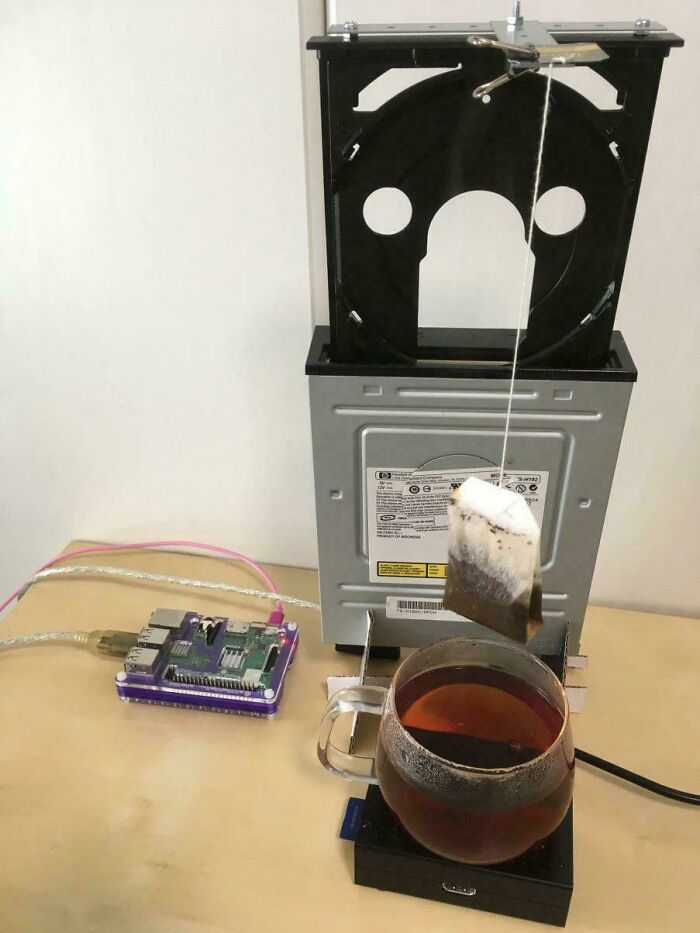 Improvised redneck engineering tea brewing setup using computer parts and a suspended tea bag over a cup of tea.