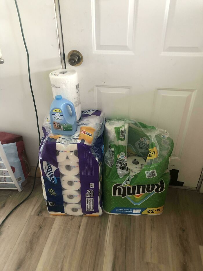 Stacked paper towels and laundry detergent placed in front of a door showing a simple redneck engineering setup.