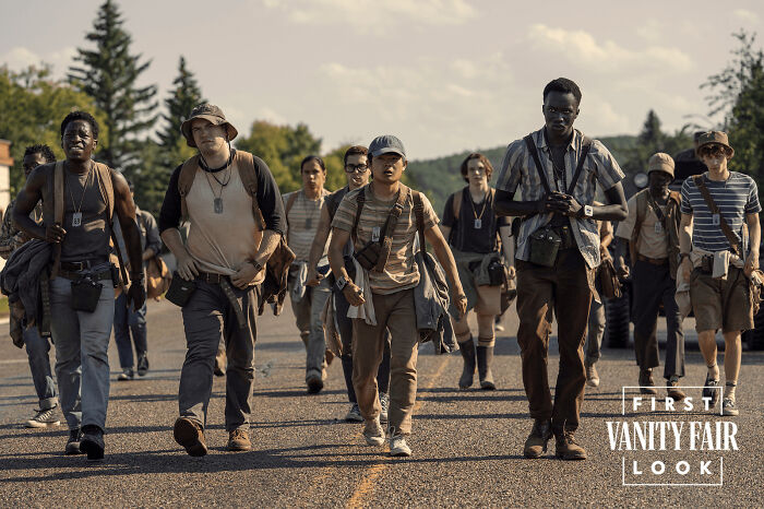 Group of young adults walking on a road in casual adventure gear, illustrating absurd movie and TV details in a scene.