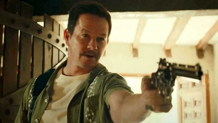 Man pointing a gun in a scene illustrating hilariously absurd movie and TV details that seem made up yet accurate.